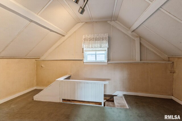 bonus room featuring dark colored carpet, wooden walls, and lofted ceiling