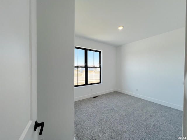 carpeted spare room with baseboards, visible vents, and recessed lighting