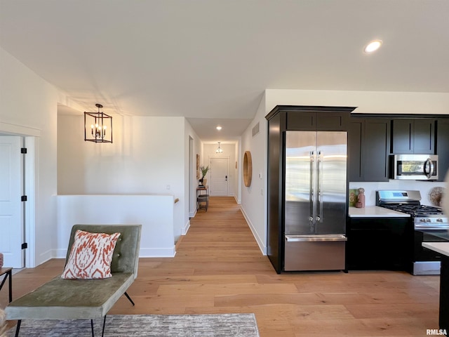 kitchen featuring stainless steel appliances, light countertops, visible vents, light wood-style flooring, and baseboards