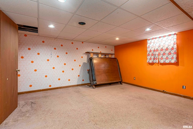 carpeted empty room with a paneled ceiling