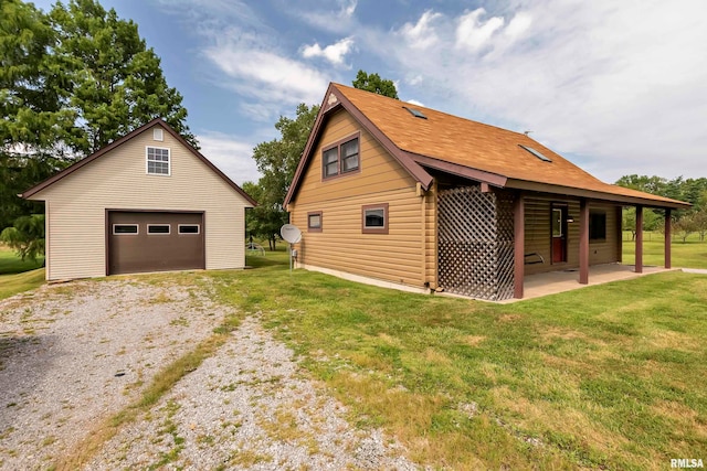 view of home's exterior with a garage, an outbuilding, a patio area, and a lawn