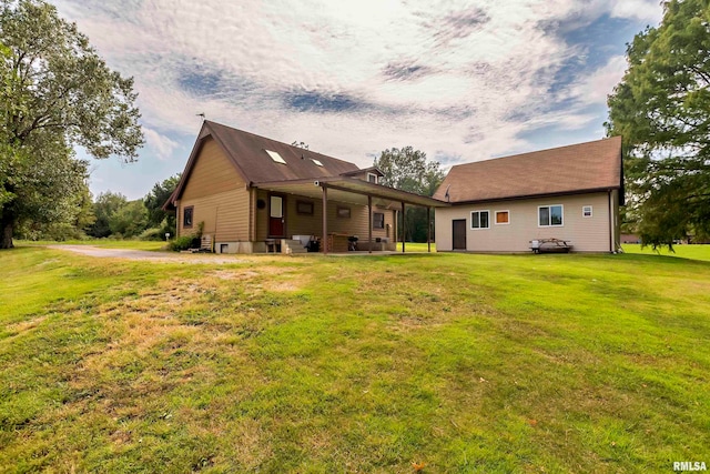 rear view of property featuring a lawn