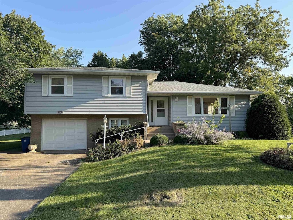 split level home with a garage and a front lawn