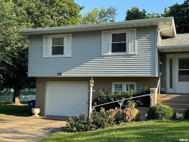 tri-level home featuring a garage and a front yard