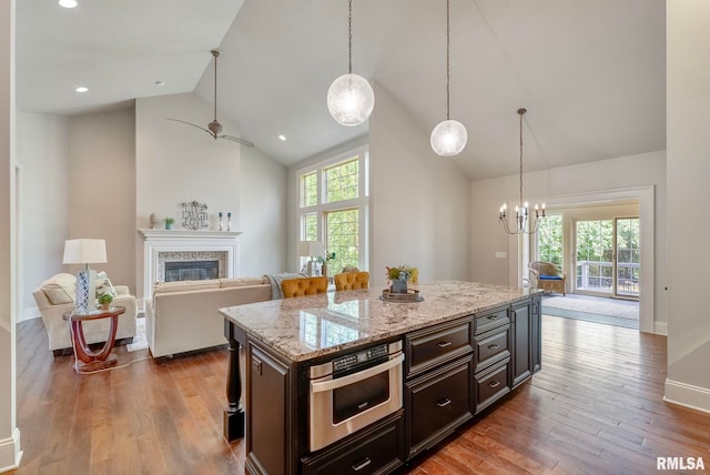 kitchen with stainless steel oven, hardwood / wood-style flooring, dark brown cabinetry, and high vaulted ceiling