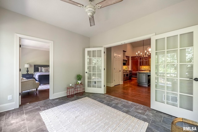 living area with ceiling fan with notable chandelier and dark hardwood / wood-style flooring