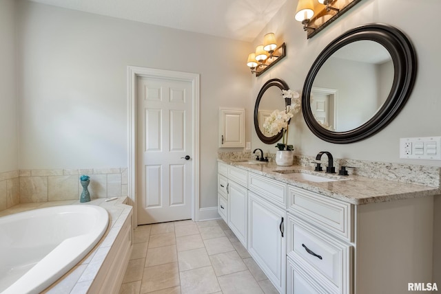 bathroom with tile patterned floors, tiled tub, and vanity