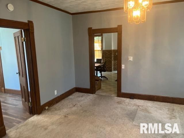 empty room with carpet floors, an inviting chandelier, and ornamental molding