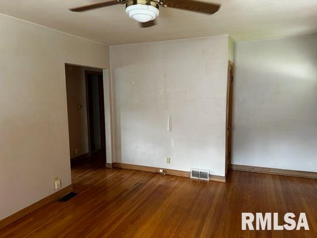 empty room with ceiling fan and dark hardwood / wood-style floors