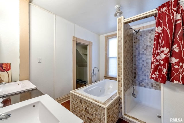 full bathroom featuring a jetted tub, walk in shower, and a sink