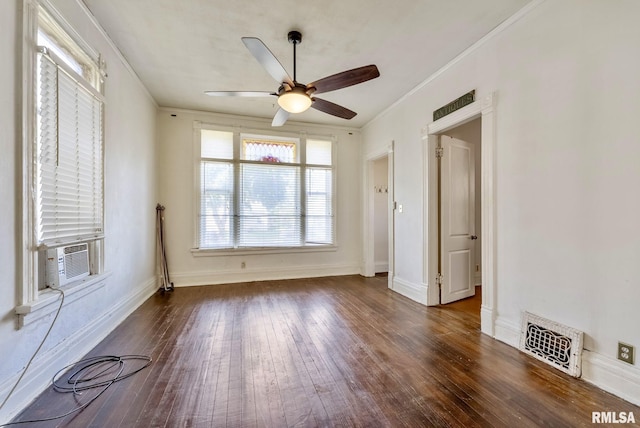 empty room featuring crown molding, a ceiling fan, visible vents, and wood-type flooring