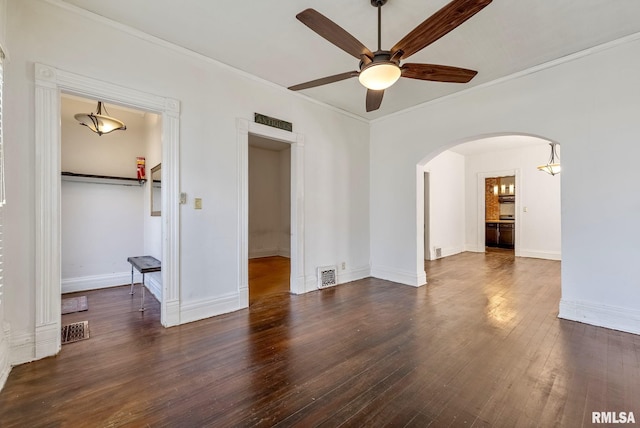 spare room with hardwood / wood-style floors, arched walkways, visible vents, and ceiling fan