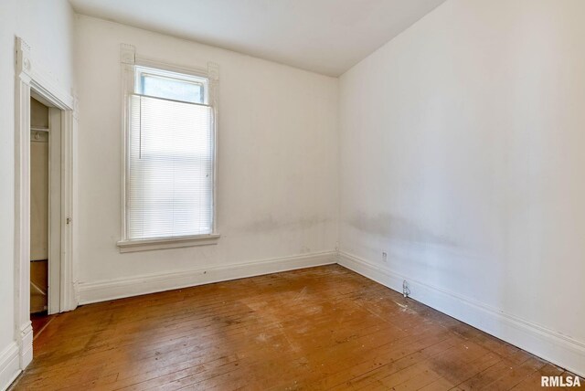 empty room with arched walkways, visible vents, a ceiling fan, and hardwood / wood-style floors