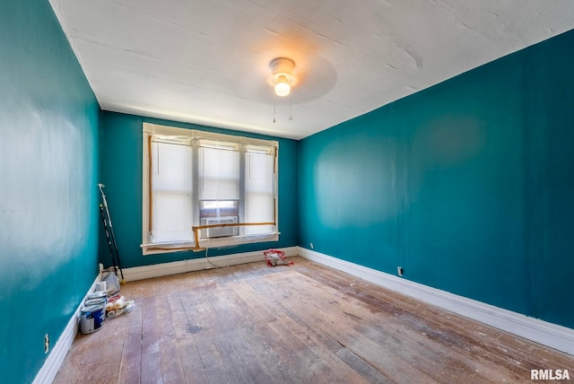 spare room with baseboards, ceiling fan, and hardwood / wood-style flooring