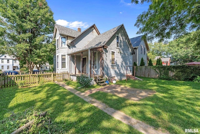 view of front of home with a chimney, a front yard, and fence