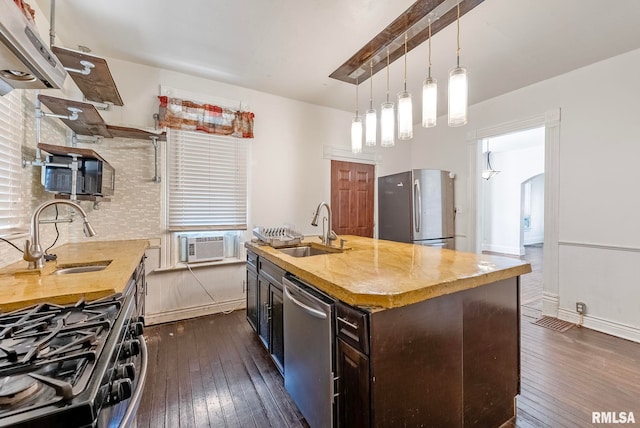 kitchen with a sink, dark wood-type flooring, appliances with stainless steel finishes, and dark brown cabinetry