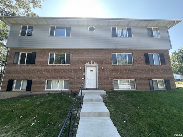 view of front of house with a front lawn and brick siding