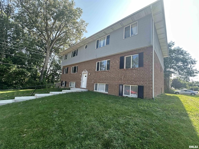 view of front of house featuring brick siding and a front yard