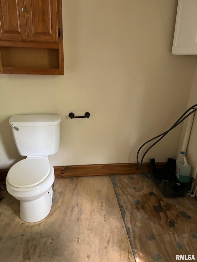 bathroom featuring toilet, baseboards, and wood finished floors