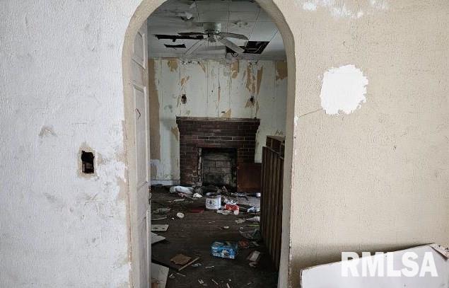 miscellaneous room with a brick fireplace and ceiling fan