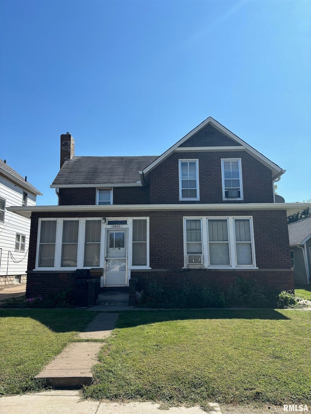 view of front facade featuring a front yard and a sunroom