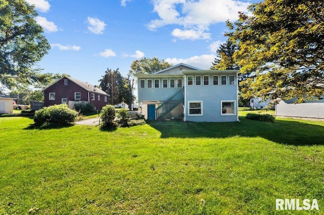 rear view of property featuring a lawn