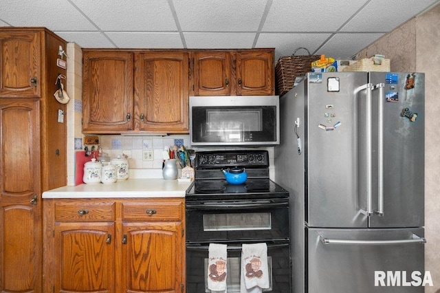 kitchen featuring tasteful backsplash, a paneled ceiling, and stainless steel appliances