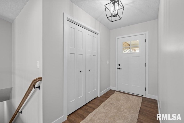 foyer with a chandelier, dark hardwood / wood-style floors, and a textured ceiling