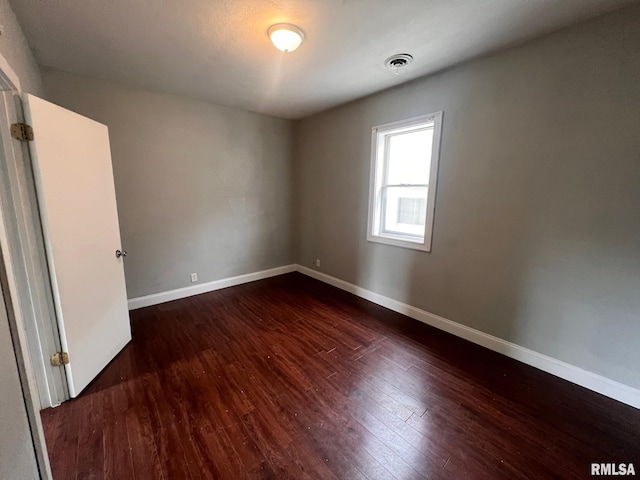 spare room with dark hardwood / wood-style floors