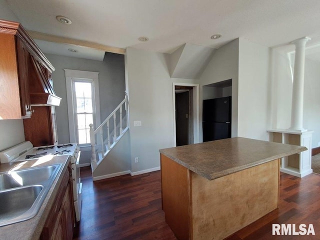 kitchen featuring black refrigerator, a kitchen island, white stove, and ornate columns