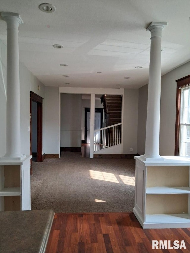 unfurnished room featuring hardwood / wood-style floors and decorative columns