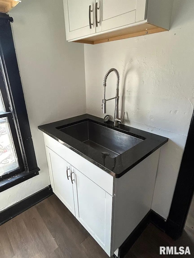 kitchen featuring dark hardwood / wood-style floors, sink, and white cabinets