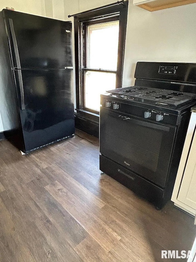 kitchen featuring black appliances, dark hardwood / wood-style flooring, and white cabinets