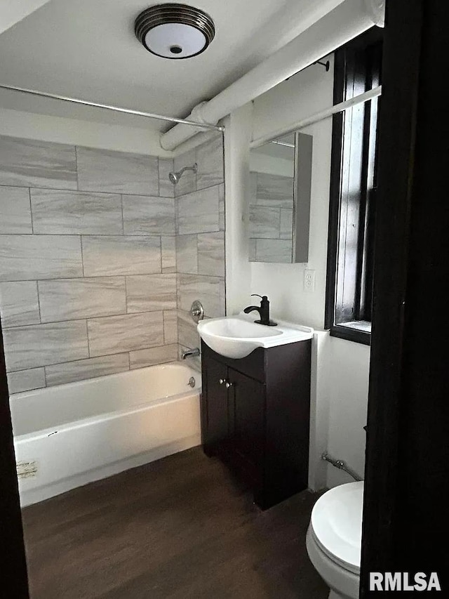 full bathroom with tiled shower / bath combo, vanity, toilet, and hardwood / wood-style floors