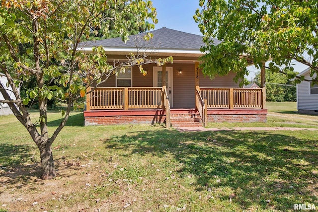 view of front facade featuring covered porch, a front lawn, and roof with shingles