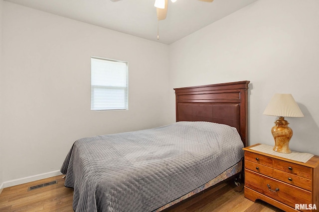 bedroom with a ceiling fan, visible vents, light wood-style flooring, and baseboards