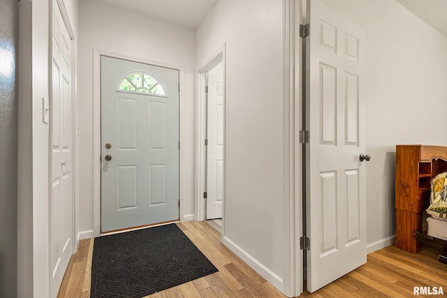 foyer with light wood finished floors and baseboards