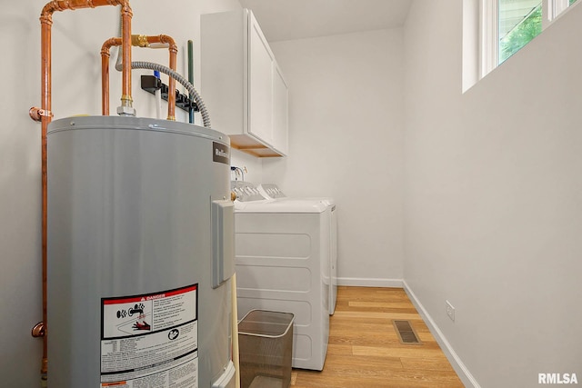 utility room with independent washer and dryer and electric water heater