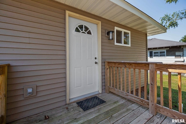 doorway to property with a deck and a yard