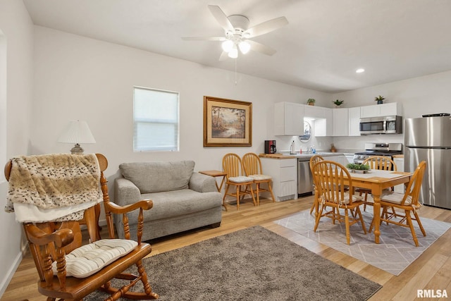 dining area featuring ceiling fan, baseboards, light wood-style flooring, and recessed lighting