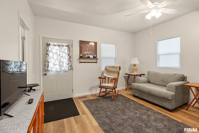 living room featuring ceiling fan and light hardwood / wood-style floors