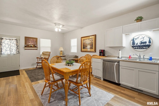 dining room with light wood-style floors, baseboards, and a ceiling fan