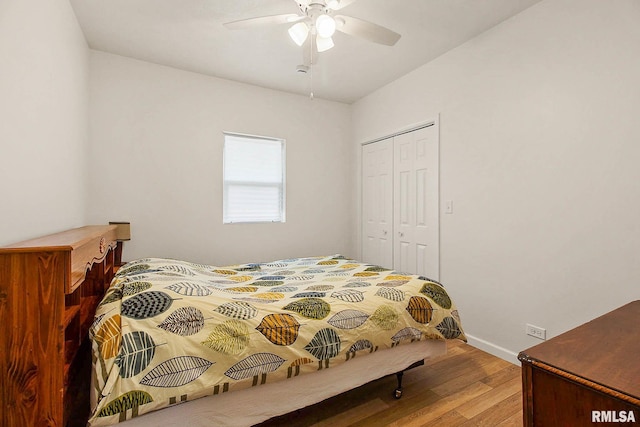 bedroom with a ceiling fan, a closet, baseboards, and wood finished floors