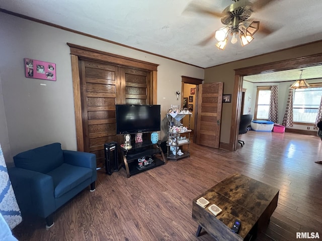 living room featuring ornamental molding, ceiling fan, dark hardwood / wood-style floors, and a textured ceiling