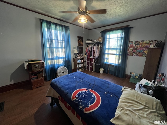 bedroom with ceiling fan, hardwood / wood-style flooring, and a textured ceiling