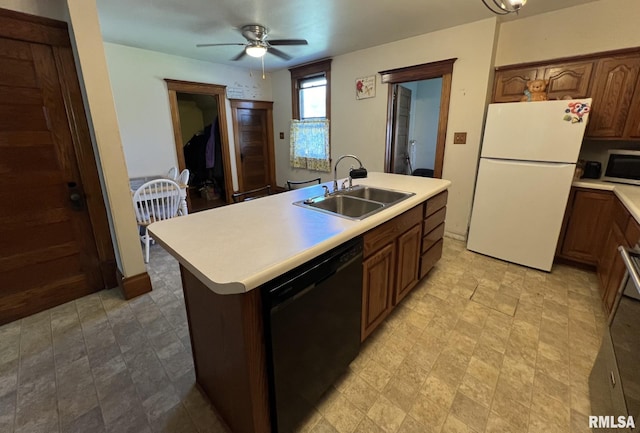 kitchen featuring white fridge, dishwasher, a kitchen island with sink, sink, and ceiling fan