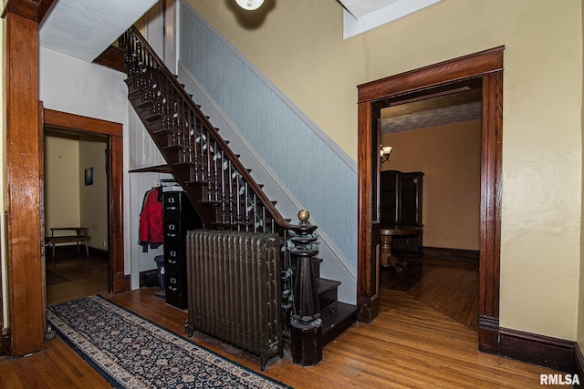 stairway featuring wainscoting and wood finished floors