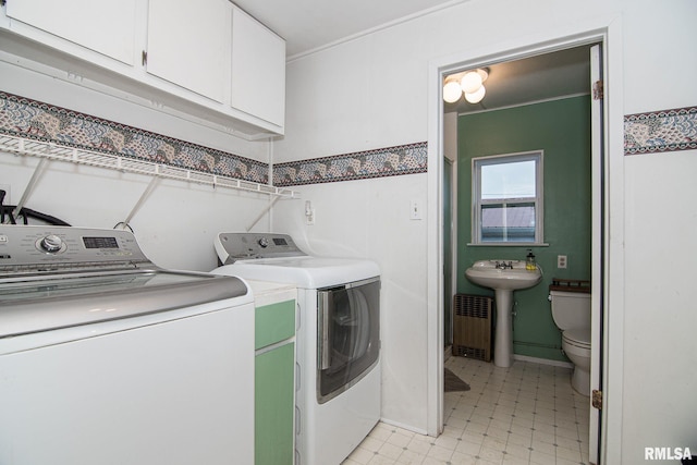 clothes washing area with light floors, washing machine and dryer, laundry area, and a sink