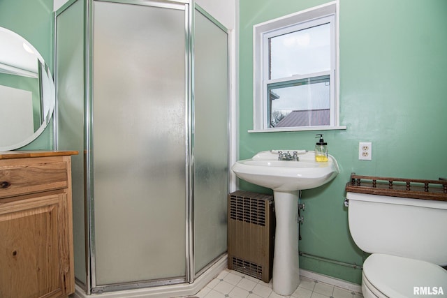 full bathroom featuring a stall shower and toilet