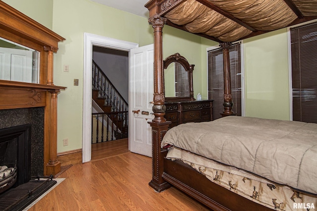 bedroom with a fireplace and wood finished floors